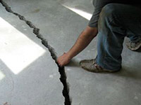 a severely damaged cracked concrete slab floor in Clemmons