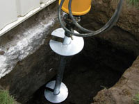 Installing a helical pier system in the earth around a foundation in High Point