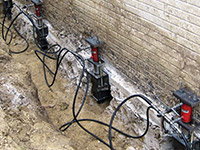 Using foundation push piers to lift a foundation during a repair in Kernersville.